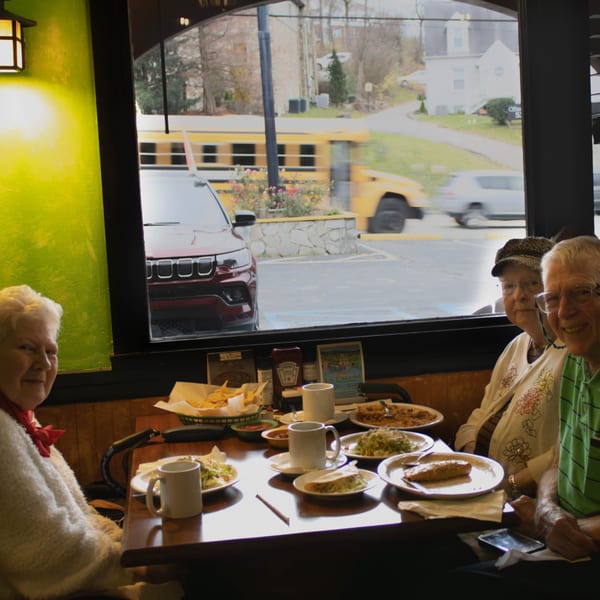 Three elderly people dining at La Calera Mexican Bar & Grill, with food and drinks on the table.
