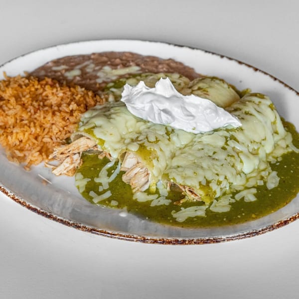 Chicken enchiladas with green sauce, melted cheese, sour cream, rice, and refried beans.