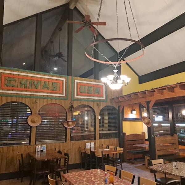 Interior of La Calera Mexican Bar & Grill with wooden decor, sombrero accents, and dining tables.