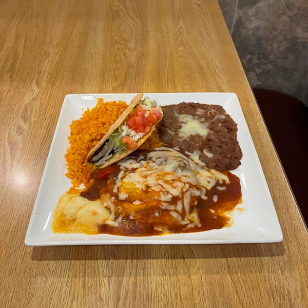 A La Calera Mexican combo plate with enchiladas, rice, refried beans, and a taco.